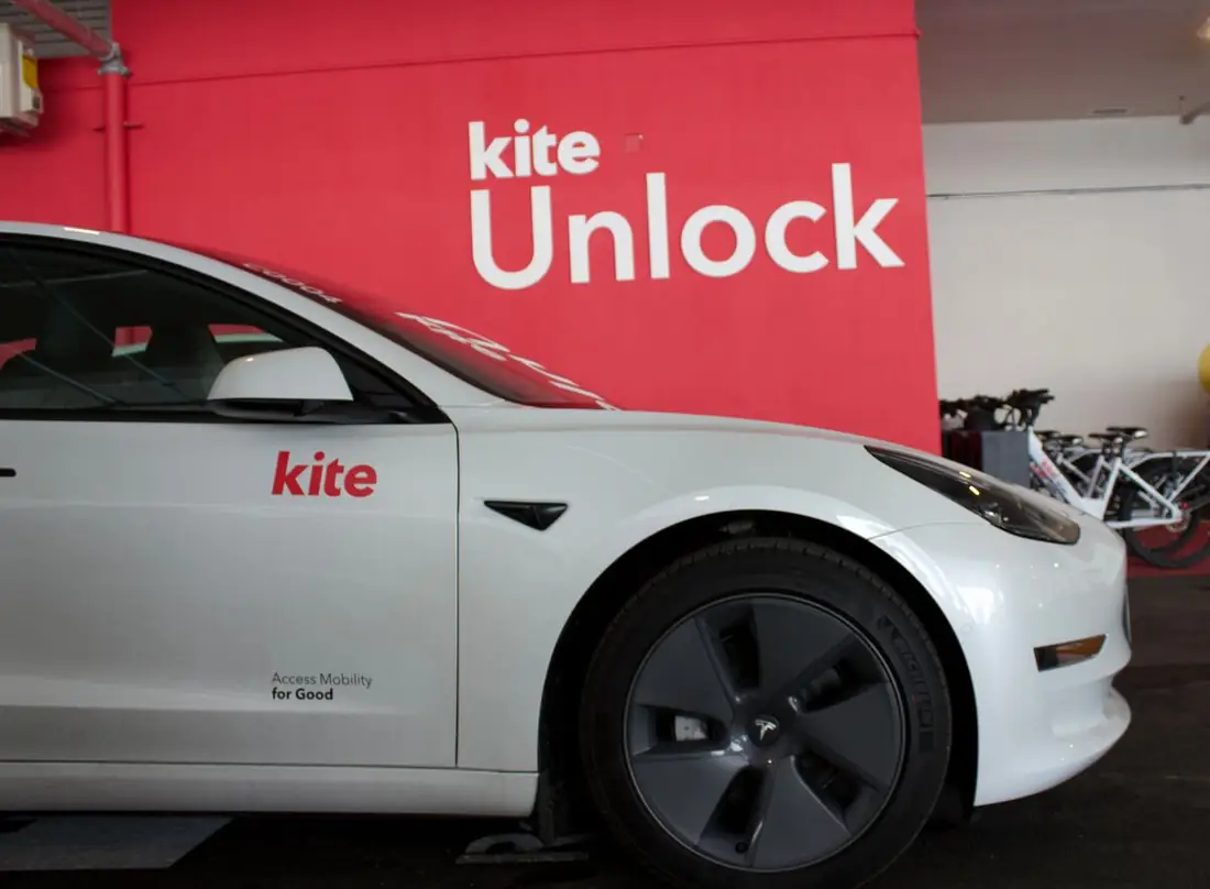 A Kite car parked at the Maple House hub by the Kite Unlock wall